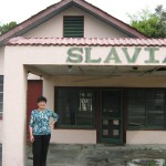 Judy Duda, long time Slavia resident in front of structural icon known as "Stanko's store"  (photo - CMF Public Media)