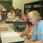Nancy Herbon (center) and Susan Donovan (right) check in patients 